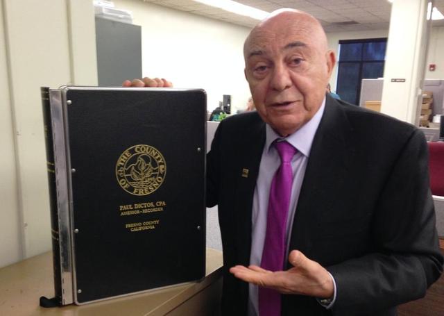 Fresno County Assessor-Recorder Paul Dictos holds a bound volume of recorded documents, one of about 20,000 books of property records and other types of documents that are held by his office dating to the county’s origins in the 1850s.